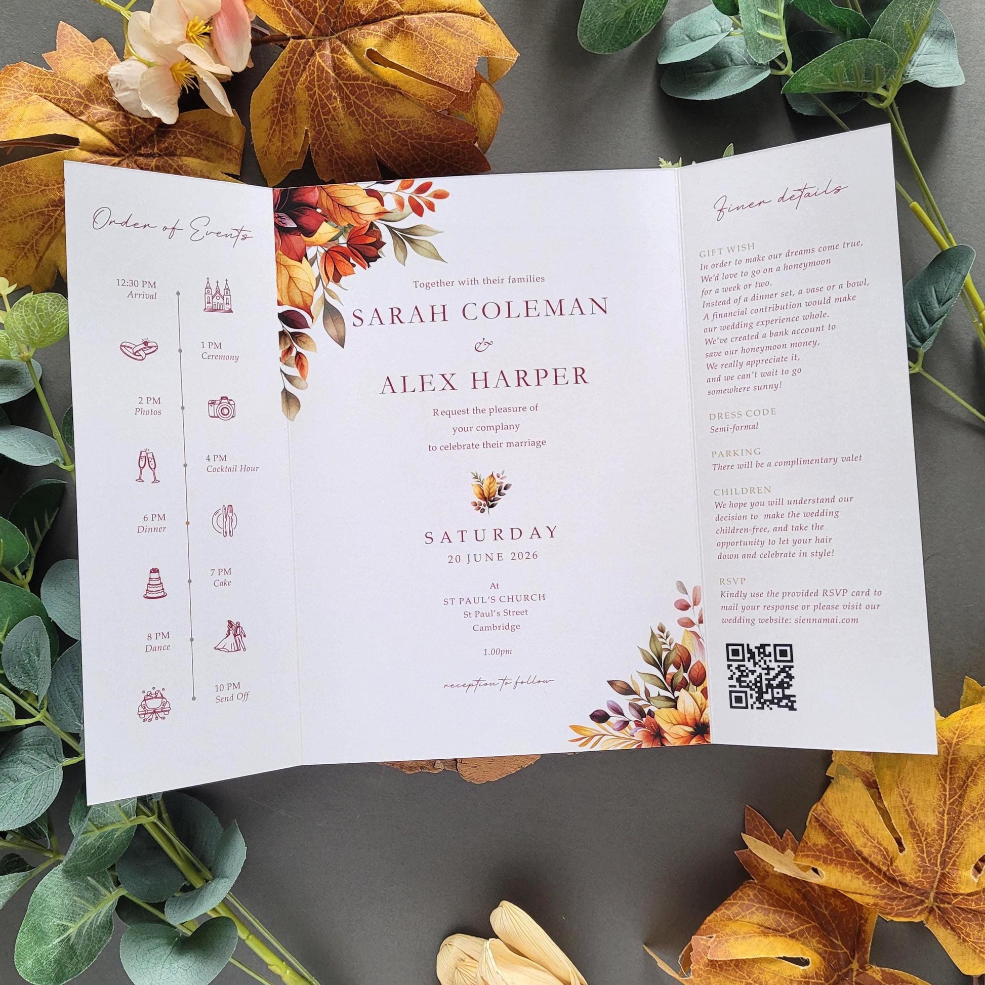 a wedding invitation with autumn leaves and flowers surrounding it.