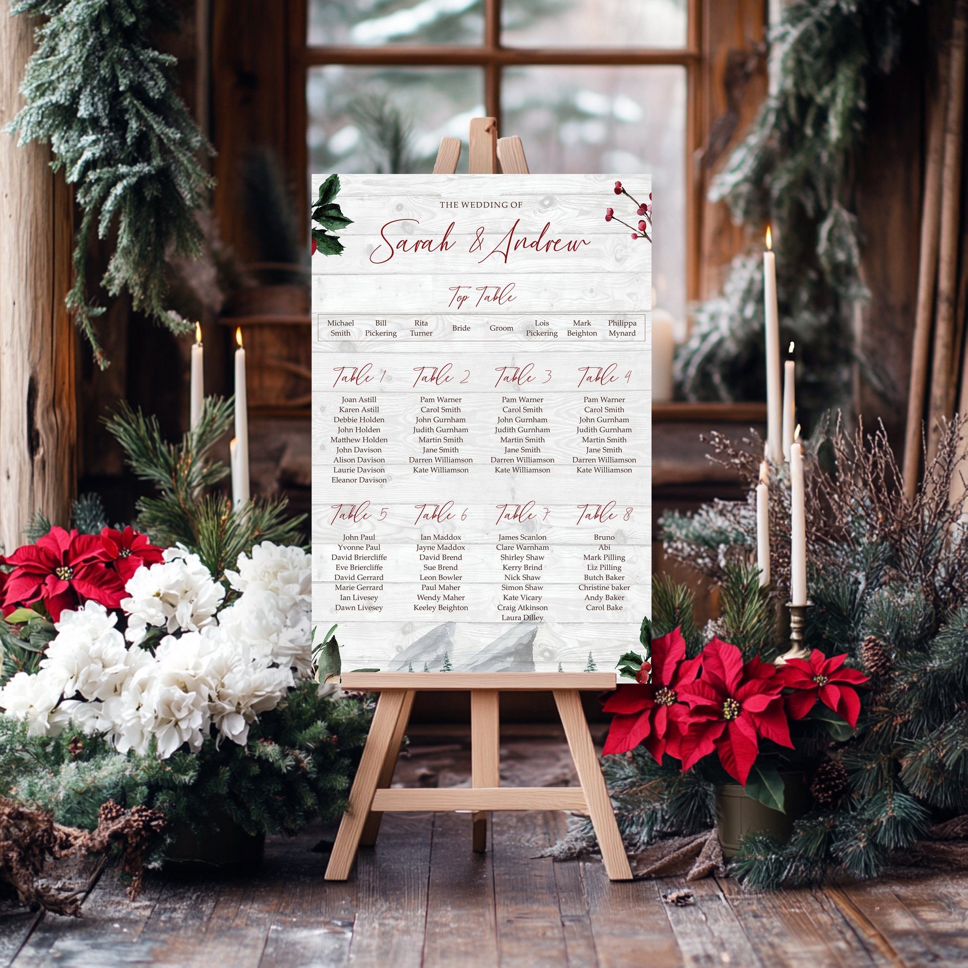 A wooden easel displaying a seating plan for a wedding reception, surrounded by holiday decorations such as poinsettias and pine branches.