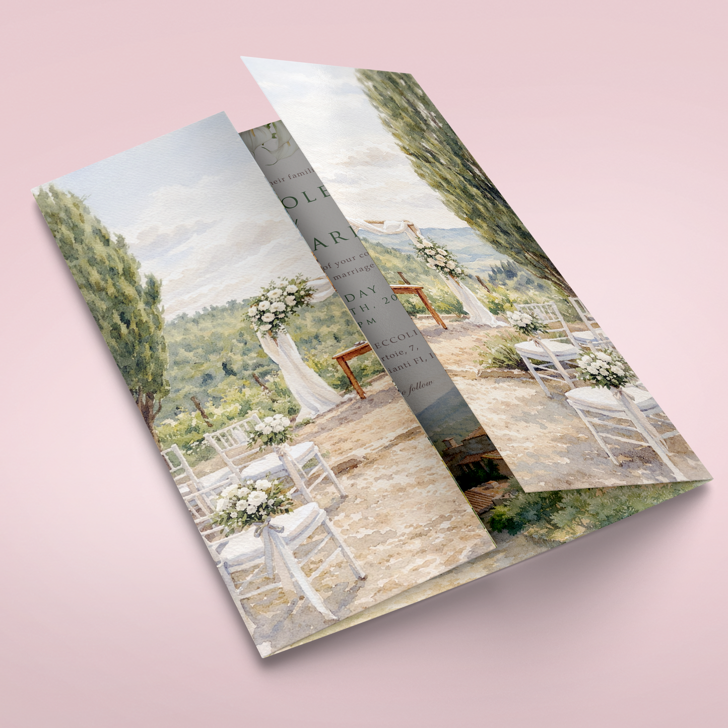A folded printed brochure or program featuring a scenic outdoor wedding venue scene, shown standing open on a soft pink background.