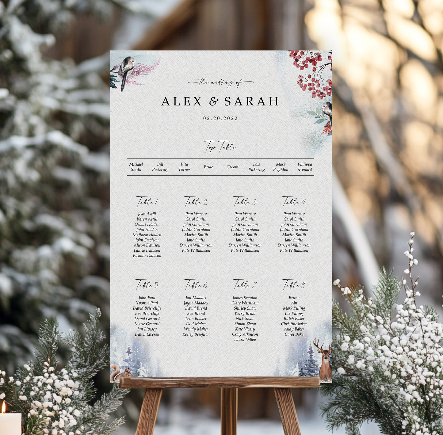 a wedding seating plan for the wedding of Alex & Sarah, dated February 20, 2023. The plan is organized into tables numbered 1 through 8, each with a list of names seated at that table. The seating plan is presented on a wooden easel, with a blurred background featuring snow-covered trees and bushes.
