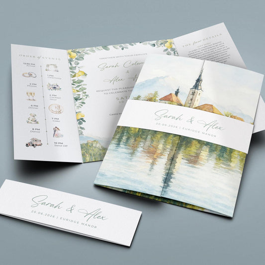A wedding invitation featuring a watercolor painting of a church and a lake, along with details about the wedding ceremony and reception.